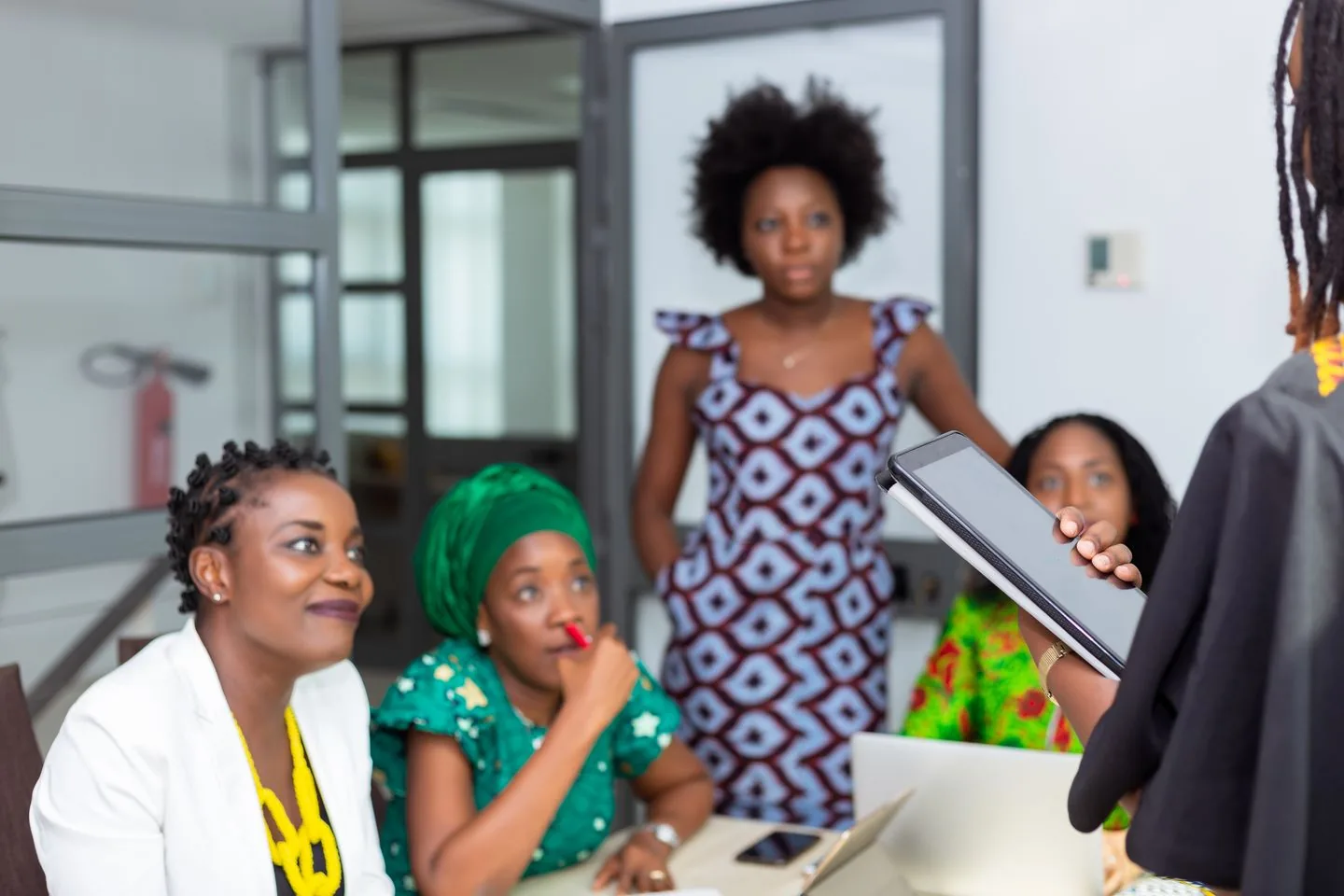 Colleagues discussing a project around a table in a bright office